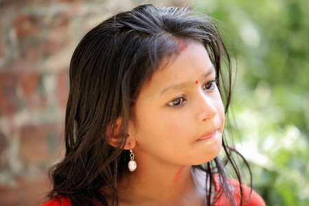 PANAUTI, NEPAL - OCTOBER 16: Nepalese young girl crosses the suspension bridge over Punyamati river as she comes back from school on October 16, 2012 in Panauti-Kavrepalanchok distr.-Bagmati zone-Nepal.のeditorial素材