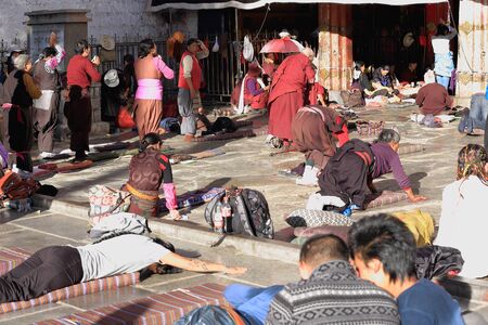 LHASA, TIBET, CHINA - OCTOBER 19: Tibetan faithfuls pray and prostrate in Barkhor square at the W.entrance to the 25000m2 Jokhang-House of Buddha temple on October 19, 2012. Lhasa-Tibet.のeditorial素材