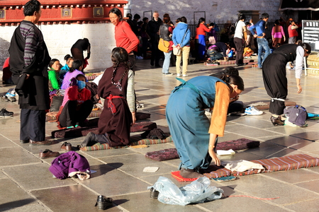 LHASA, TIBET, CHINA - OCTOBER 19: Tibetan devotees pray and prostrate in Barkhor square at the W.entrance to the Jokhang-House of Buddha temple on October 19, 2012. Lhasa-Tibet.のeditorial素材