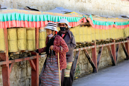 LHASA, TIBET, CHINA - OCTOBER 19: Tibetan buddhist devotees do the Kora-clockwise circumambulation around the Jokhang-House of Buddha temple and the Potala Palace on October 19, 2012 in Lhasa-Tibet.のeditorial素材