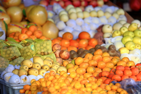 Various fruits tangerinesorangespearskiwispommegranatesapplesgrapefruits in a stall of a market in the lower area. Gyantse city and countyShigatse pref.Tibet.の写真素材