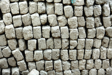 Lots of adobe bricks stacked beside the wall of a traditional tibetan house in the lower area of...