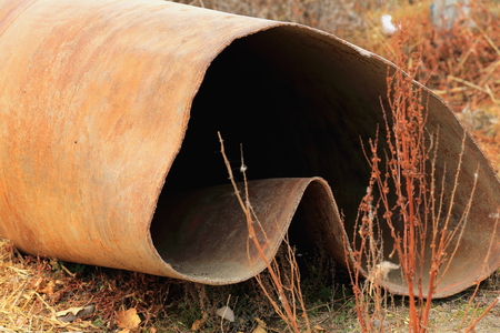 Rusty creased old iron pipe on the floor. Banks of branch of the Yarlung Tsangpo-river flowing past hamlet near Shigatse city-county and pref.-Tibet.の写真素材