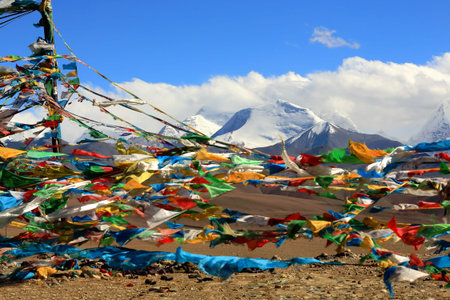 Prayer flags over Tong La pass framing mounts: left-Colangma 6952 ms.and right-Gyao Kang 6720 ms.-Lapche or Labuche Kang Himal section-Friendship Highway between Tingri and Nyalam towns-Tibet.の写真素材