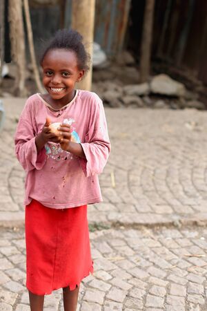 KOMBOLCHA, ETHIOPIA-MARCH 24: Young girl plays with a plastic ball she has in hand on March 24, 2013. Kombolcha town at 1842 ms.-Debub Wollo zone-Amhara region-Ethiopia.のeditorial素材