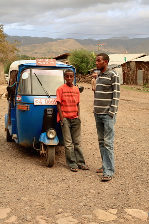 KOMBOLCHA, ETHIOPIA-MARCH 24: Man and boy wait beside an autorick outside Bete Gebriel-St.Gabriel church compound for the religious service to begin on March 24, 2013. Debub Wollo zone-Amhara region.のeditorial素材