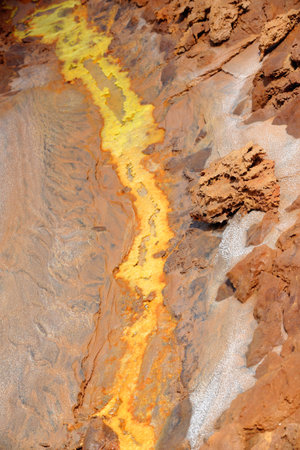 Dallol mount rising over the surrounding salt flats of Lake Karum or Assale. Colored deposits of...
