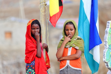 BERAHILE, ETHIOPIA-MARCH 29: Schoolgirls raise the national flag on March 29, 2013 in the playground of the school at Berahile town-Danakil desert limits-Administrative zone-Afar region.のeditorial素材