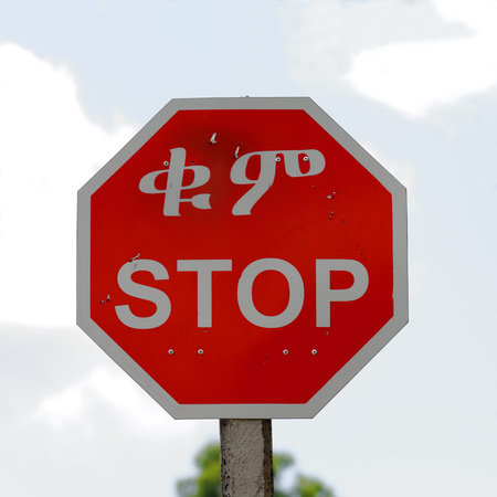 Stop road signal showing ethiopian writing. Maychew town on route from Mek'ele to Kombolcha at 2479...