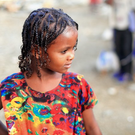 BERAHILE, ETHIOPIA-MARCH 29, 2013: Schoolgirl waits on the playground to enter her classroom-textbooks and notebooks in hand at the Berahile town school on March 29, 2013. Afar region.のeditorial素材