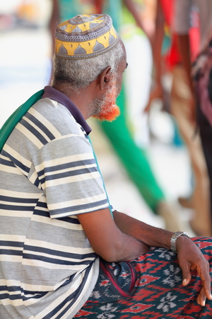 BERAHILE, ETHIOPIA-MARCH 29, 2013: Red bearded afar man monitors the children queuing to enter their classrooms-playground of the school at Berahile town on March 29, 2013. Afar region.のeditorial素材