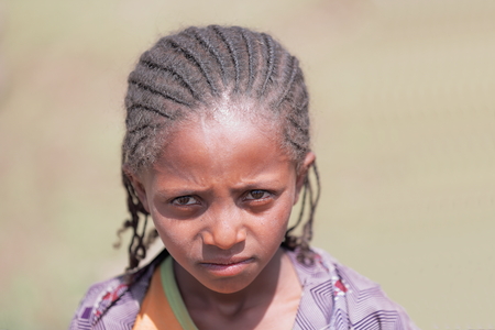 N.SHEWA ZONE, ETHIOPIA-MARCH 30: Sad-eyed girl of the oromo people wears little braids of hair as example of the headdresses used in the region on March 30, 2013. Hamlet in N.Shewa zone-Oromia region.のeditorial素材