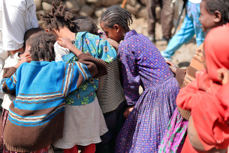 OROMIA, ETHIOPIA-MARCH 31: Local girls and boys swirl around a tourist visiting their hamlet and...