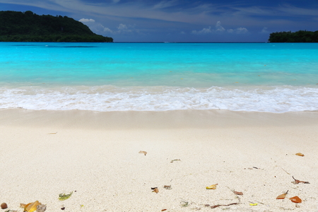 The coral white sands and quiet turquoise blue waters of the beach at Port Olry framed by Dolphin island to the North and Malmas island to the South. Espiritu Santo island-Sanma province-Vanuatu.の写真素材
