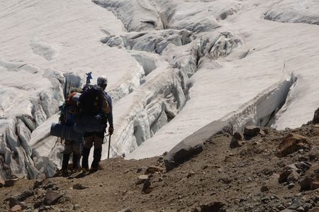 Two mountain climbers looking at a crevasseの写真素材