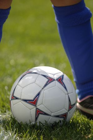Soccer ball at bottom of soccer player's feetの写真素材