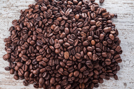 Roasted coffee beans on textured wood tableの写真素材