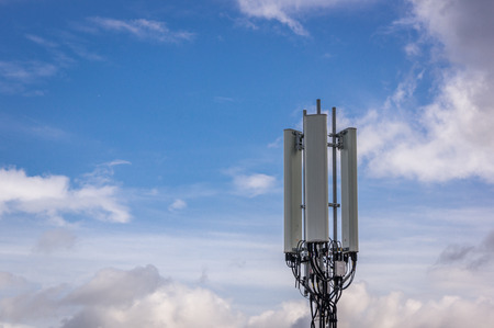 Cell tower communication tower with blue sky and light cloudsの写真素材