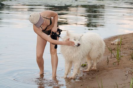 Girl with samoed in waterの写真素材