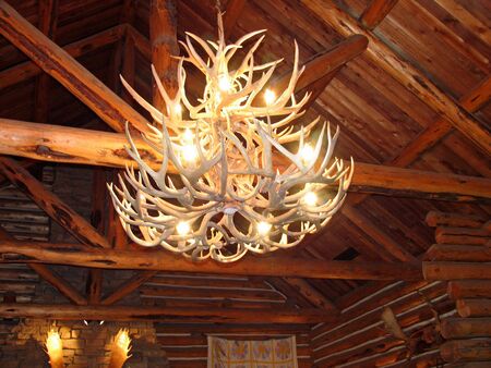 Chandelier made of antlers hanging in a rustic cabinの写真素材