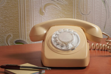 Retro telephone on wooden table in front gradient background.