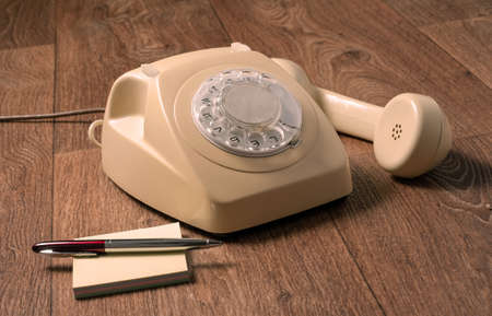 Retro telephone on wooden table in front gradient background.の写真素材