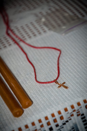 A cross on a string and candles for the rite of baptism
