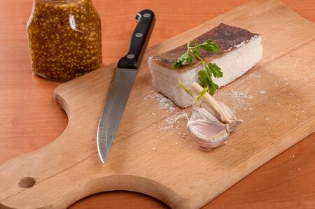 Sliced lard on wooden table with onion and knife horizontal. Fresh, rural, homemade products on wooden tableの写真素材