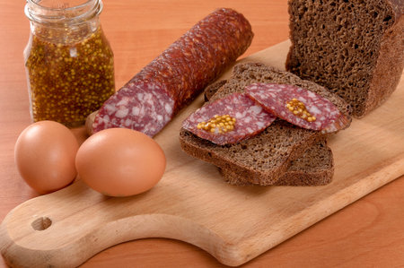 Sausage sliced with a knife on a wooden table. Sausage on wooden tableの写真素材