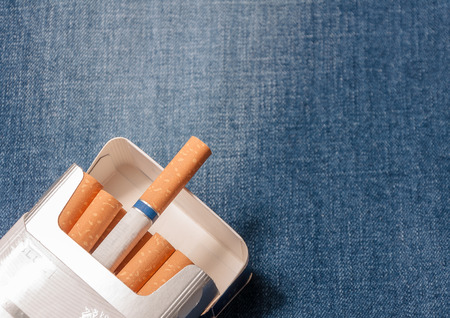 Closeup to jeans pocket with cigarettes. Cigarettes in blue denimの写真素材