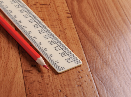 Red pencil and ruler on a wooden background. School supplies.の写真素材