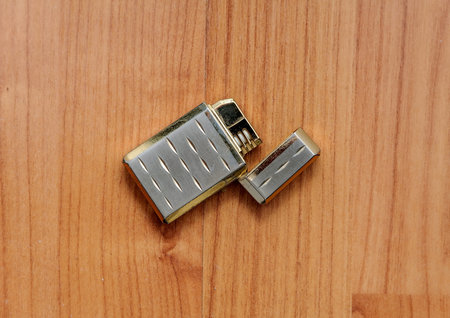 Old retro golden lighter closeup on vintage boards.