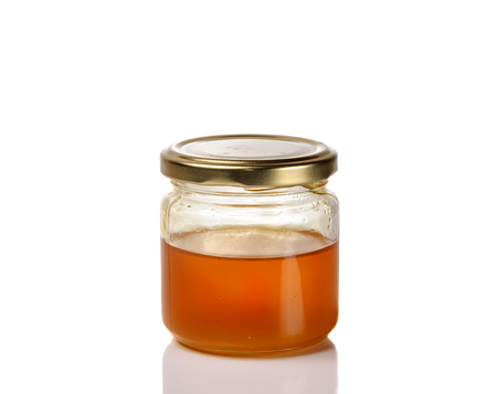 Jar of light golden honey isolated on a white background.の写真素材