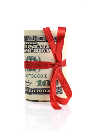Bundle of bills of one hundred dollars tied with a red ribbon. Dollars isolated on white background.の写真素材