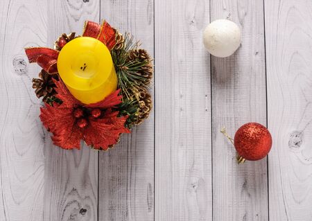 A yellow candle and a New Year pine wreath on an old wooden background.の写真素材