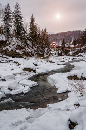 Winter landscape. Mountain river flows from the rocks. Snow and mountain riverの写真素材