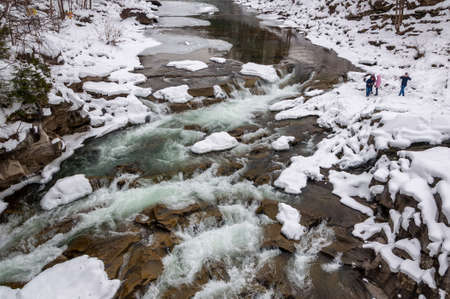 Winter landscape. Mountain river flows from the rocks. Snow and mountain riverの写真素材