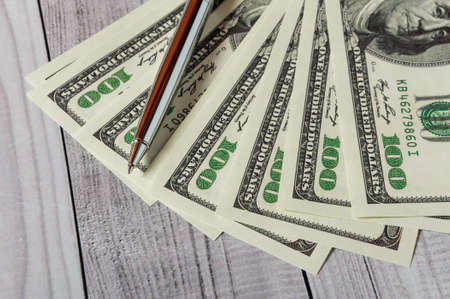 Notepad, pen and money on a light wooden background.の写真素材