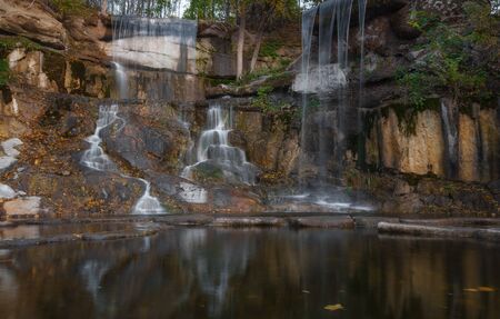Beautiful waterfall in the rays of the evening sun. Waterfall in autumn.の写真素材