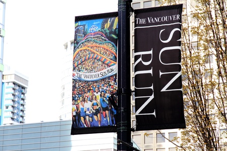 VANCOUVER, CANADA - April 21, 2013 -The city banners for the 2013 Vancouver Sun Run seen on a lamp post amongst the sky scrapers of downtown Vancouver, Canada のeditorial素材