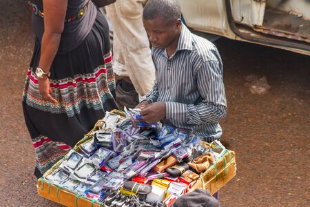 KAMPALA, UGANDA - OCTOBER 03, 2012.  A man sells cell phone cases at the taxi park in Kampala, Uganda on October 03,2012.のeditorial素材