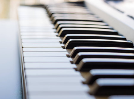 An electronic keyboard is in a bright room placed next to an open window. This is a bright image...