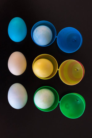 Easter eggs are filled  and viewed from above.  The plastic eggs are filled with dyed eggs and...