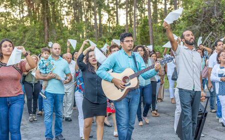 Port St. Lucie, Florida; USA; October. 14, 2017.  A south Florida catholic community walks the streets waving white flags and singing worship music. A guitarist and his acoustic guitar. leads the way.のeditorial素材