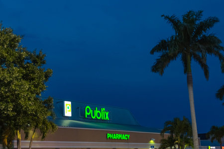 A Publix storefront image taken during twilight hours as seen from the parking lot. The neon signs...