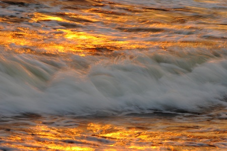 Golden sunset and sea wavesの写真素材