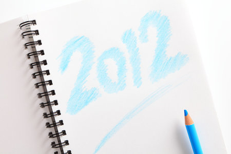 notebook ( writed 2012) and blue pencil on white background