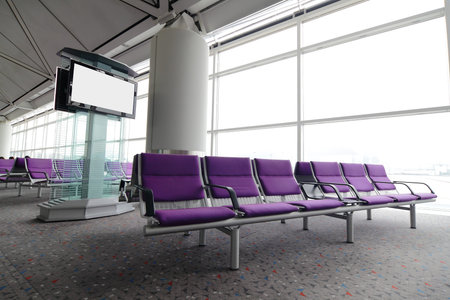 LCD TV and row of purple chair at airport in Hongkongのeditorial素材