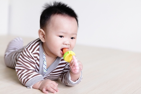 Cute Baby crawling on living room floor with home background, baby is a cute asian childの写真素材