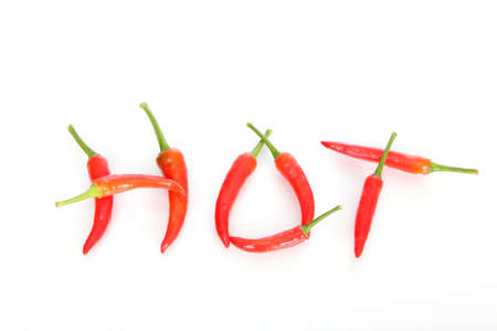 Hot written with red chili peppers isolated over white backgroundの写真素材